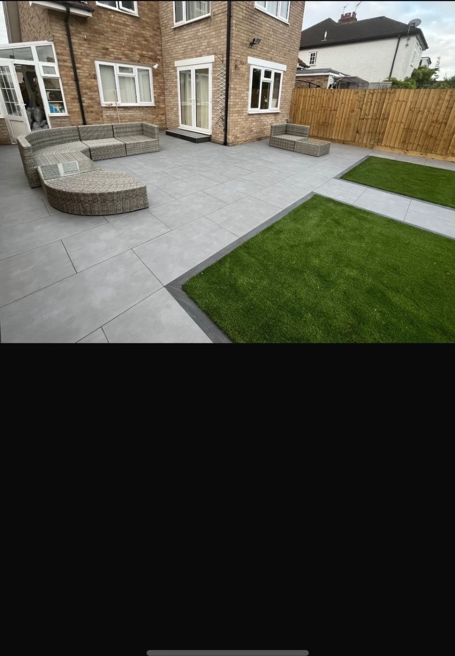 Contemporary grey porcelain patio with artificial grass lawn and rattan garden furniture