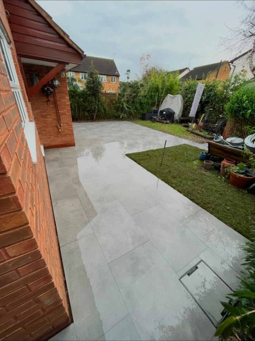 Contemporary light grey porcelain tile patio with matching recessed manhole cover